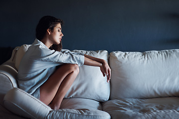 Image showing Depression, sad and woman relaxing on sofa in living room for loneliness at modern house. Mental health, upset and unhappy young female person sitting, resting and thinking on couch at apartment.