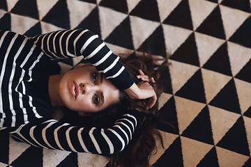 Image showing Portrait, woman or lying on carpet in fashion, couture and clothing for minimalist style aesthetic. Edgy, female person and trendy as texture, pattern and design of contemporary fabric and textile