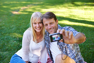Image showing Selfie, camera and couple in a park, love and happiness with marriage and romance with summer or nature. Photograph, outdoor or memory with man or woman with relationship, relax or date with sunshine