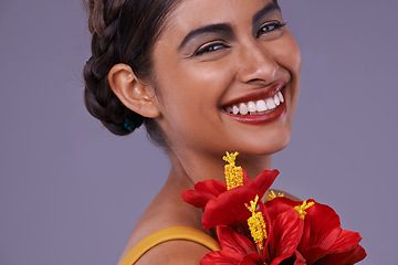 Image showing Studio, woman and portrait with flower for makeup, cosmetics and floral beauty with smile. Happy, Indian person and face with dermatology for luxury, wellness and sustainability on purple background