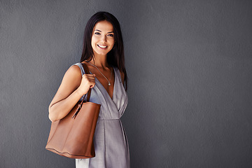 Image showing Studio, portrait and handbag with woman, smile and accessories with dress and joy. Fashion, face and model with confidence, beauty and happiness with purse and style isolated on gray wall background