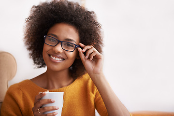 Image showing Portrait, smile and glasses on woman in home lounge, coffee and happy for natural lady. Head, confidence and eye wear with curly hair for female person from London, positive in living room or house