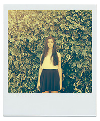 Image showing Bush, leaves and portrait of girl in nature for peace, zen and relax outdoors on polaroid. Female person, teenager and fashion in garden for trendy, style and summer vacation with serious face