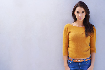 Image showing Portrait, fashion and confidence of woman on a wall, model or girl isolated on a white background mockup space. Trendy, serious and young person in casual clothes, jeans and stylish sweater in Italy