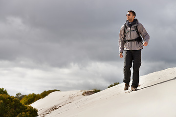 Image showing Travel, fitness or man in desert with backpack for adventure, journey or resort, location or explore. Freedom, holiday or male backpacker in Egypt for sand dunes walking, wellness or hiking in nature