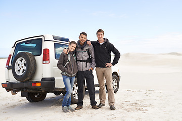 Image showing Friends, portrait and people with car in desert, travel and tourism in Dubai for safari and road trip. Adventure, journey and transportation, offroad vehicle or 4x4 on vacation with break outdoor