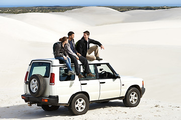 Image showing Relax, car and friends sitting on roof for off road drive, summer holiday and communication in sand dune. Car, transportation and people in nature for getaway vacation, travel and journey in Mexico