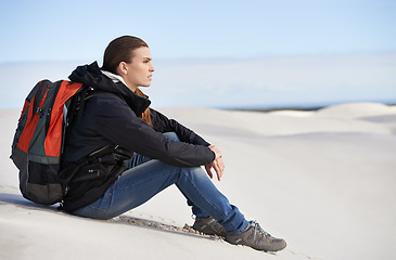 Image showing Hiking, sand dunes or woman in nature to relax for adventure, desert landscape and travel for holiday. Break, thinking or nomad explorer in Sahara terrain, outdoor and dry climate for view or scenery