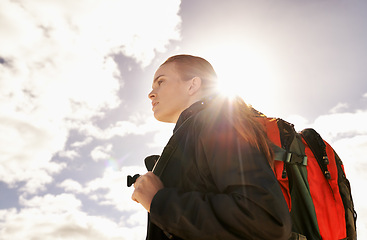 Image showing Woman, hiking and walking by blue sky for fitness adventure in nature and extreme sport in hot sunlight. Athlete, below and survival gear for environmental exploration, travel and trekking in oman