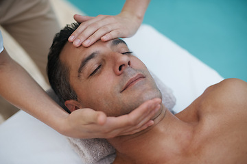 Image showing Hotel, spa and man relax for facial massage on table in resort, calm and care for body in vacation. Holiday, luxury and male person on break for weekend and lodge with treatment for skincare