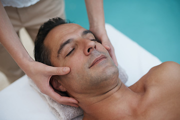 Image showing Outdoor, spa and man relax for facial massage on table in hotel, calm and care for body in vacation. Holiday, luxury and male person on break for weekend, resort and lodge with treatment for skincare