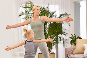 Image showing Yoga, exercise with mom and daughter in living room, stretching out arms for balance and bonding. Woman, young girl and fitness together at family home, health and wellness with love and care