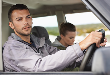 Image showing Couple, car and driving on roadtrip with travel for adventure, vacation and concentration of driver in countryside. Woman, man and serious in transport for holiday journey, tourism and honeymoon trip