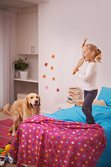 Image showing Girl, child and puppy with playing on bed for karaoke, bonding and singing in bedroom of home with brush. Kid, golden retriever and dog for companion, dancing and relax with pet care in apartment