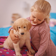 Image showing Girl, child and golden retriever with hug on bed for playing, bonding and protection in bedroom of home with love. Kid, puppy and dog for companion, affection and embrace with pet care in apartment