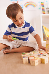 Image showing Boy, child and building blocks for toys, playing and learning with development and growth at home in playroom. Fun, activity and playful with wood bricks, young toddler kid and educational games
