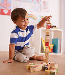 Image showing Home, boy or child with building blocks for playing and learning for development or growth in playroom. Happiness, education and playful with activity, young toddler kid and fun games for creativity