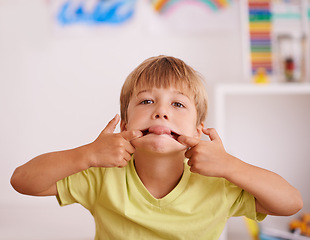 Image showing Boy, child and funny face with tongue out, goofy and playful in playroom, mischievous or naughty with humor. Comic, crazy and silly facial expression for playing, fun and amusement with kid at home