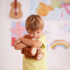 Image showing Child, boy and hug teddy bear, toys for safety and security in childhood with comfort and care in playroom. Peace, calm and affection with stuffed animal, soft and fluffy for love and youth at home