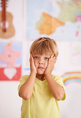 Image showing Child, boy and hands on face for stress or worry in playroom, anxiety with serious facial expression and fear. Scared, concern or unhappy with fail or mistake, negative reaction for crisis or problem