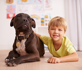 Image showing Boy child, dog and portrait, happy with pet and friends in playroom for love and loyalty at home. Youth, kid and bonding with puppy, adoption or foster for animal care and relax on floor with smile