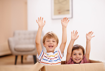 Image showing Children, box and play in living room for sibling, child and surprise for hand in air and laugh for joy in home. Young kid, friend and innocent for adorable and cute with boy and carefree for excited