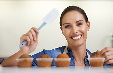 Image showing Baking, cupcakes and portrait of woman with spatula in kitchen with sweet chocolate frosting for dessert. Cooking, smile and young female baker working on muffins with culinary tool at apartment.