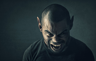 Image showing Monster, man and face with horror in studio for fantasy, demon and angry vampire with fangs, scary and terror. Werewolf, devil and creepy creature with shouting, rage and surreal on black background