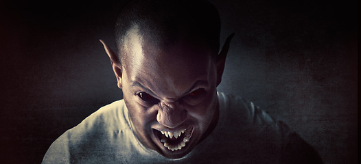 Image showing Monster, man and demon face in studio for fantasy, horror and angry vampire with fangs, scary and terror. Werewolf, devil and creepy creature with shouting, rage and surreal alien on black background