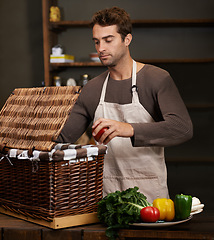 Image showing Man, basket and business owner with vegetables or groceries in a bag for cooking or diet in kitchen. Chef packing, shopkeeper and person sorting healthy food dinner or packaging box of ingredients