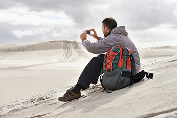 Image showing Phone, photography or man in a desert for travel, adventure or profile picture in nature. Smartphone, app and social media nomad influencer with photoshoot of sand dunes scenery on journey in Egypt