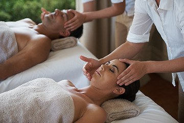 Image showing Holiday, head massage and couple relax in spa for care of body with rest on table of retreat for honeymoon. Hotel, man and woman together in resort for health, wellness and luxury for skincare