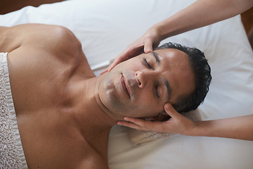 Image showing Hands, head massage and top view of man at salon for skincare, peace and calm at luxury resort at table for wellness. Above, therapy and masseuse at spa for face treatment, health and person relax