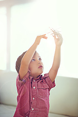 Image showing Children, toys and boy playing with helicopter in a house for fun, curious or morning games in his home. Plane, flying or kid in a living room with aircraft model, dreaming or future pilot fantasy