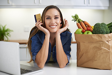 Image showing Happy woman, laptop and credit card with grocery bag for online shopping, order or payment in kitchen at home. Portrait of female person with smile, computer or debit in purchase or delivery at house