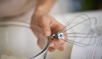 Image showing Hands, person and whisk with cookbook, kitchen and bowl for baking. Baker, muffin or pastry and food with countertop, apron and cooking for recipe preparation and recreation or hobby at home or house