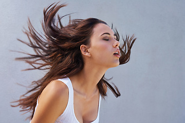 Image showing Woman, hair or shake as hairdressing, hairstyle or promo of healthy, texture or growth for scalp. Wind, long or natural style as grooming in maintenance, shine or volume in studio on grey background