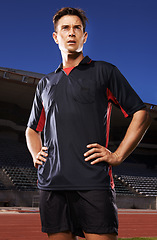 Image showing Man, sports and confident soccer player in stadium, athlete and competitive for match or game. Male person, serious face and determined for competition, outdoors and focus for football challenge