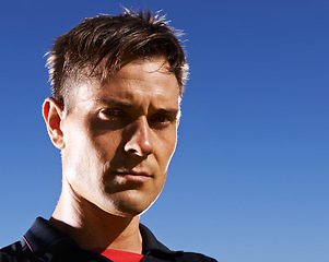 Image showing Portrait, man and athlete serious outdoor, sky background for fresh air with football player at stadium. Determined face, confident and pride in headshot with professional sportsman at training