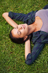 Image showing Relax, nature and woman on grass with eyes close for peace, satisfaction and good mood in outdoor park. Spring, green lawn and face of female person with happiness for rest, enjoyment and wellness