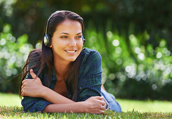 Image showing Grass, thinking and woman with headphones, listening to music and streaming audio with peace, relaxing and sunshine. Person in a park, outdoor and girl with headset and podcast with radio and sound