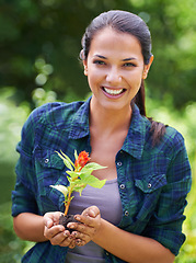 Image showing Portrait, flower and smile with woman gardening in backyard of home for growth or sustainability. Face, plant and landscaping with happy young person in garden for cultivation or horticulture