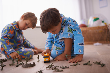 Image showing Boys, playing and children in pajamas with toys for fun with action figures, car or games. Brothers, child development and young kids bonding together in playroom for learning at family home.