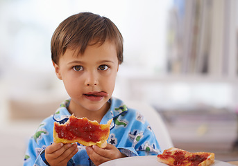 Image showing Portait, food, and breakfast for young boy eating, bread and pyjamas in home for nutrition. Children, childhood and development with toast for health, jam and snack or wellness for kid male person
