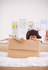 Image showing Home, portrait or costume as pirate to play in boat boxes or fantasy in bedroom or house. Kid hiding, child captain or boy in an adventure game with cardboard or monocular telescope to sail on ship