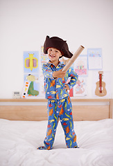 Image showing House, portrait or costume as pirate to play in fantasy in a home with telescope toy or smile. Kid sailor, child captain or happy boy in a game with pyjamas, hat or creative monocular to sail on bed