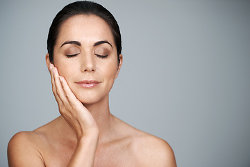 Image showing Mature, skincare and woman touching face with makeup at studio isolated on gray background mockup. Cosmetics, beauty and hand of model in facial treatment for dermatology, anti aging and eyes closed