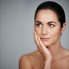 Image showing Beauty, skincare and woman touching face in makeup at studio isolated on a gray background mockup. Cosmetics, hand and model in facial treatment for dermatology, thinking and health for anti aging