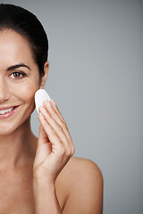 Image showing Mature woman, pad and portrait in studio, skin care and facial treatment on gray background. Female person, cotton and swab for grooming on half face, mockup space and dermatology to remove makeup