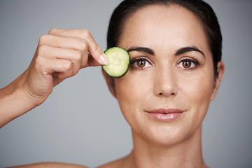 Image showing Portrait, beauty and cucumber for detox with woman in studio isolated on gray background for wellness. Face, skincare or antiaging routine and mature person with slice of fruit for dermatology